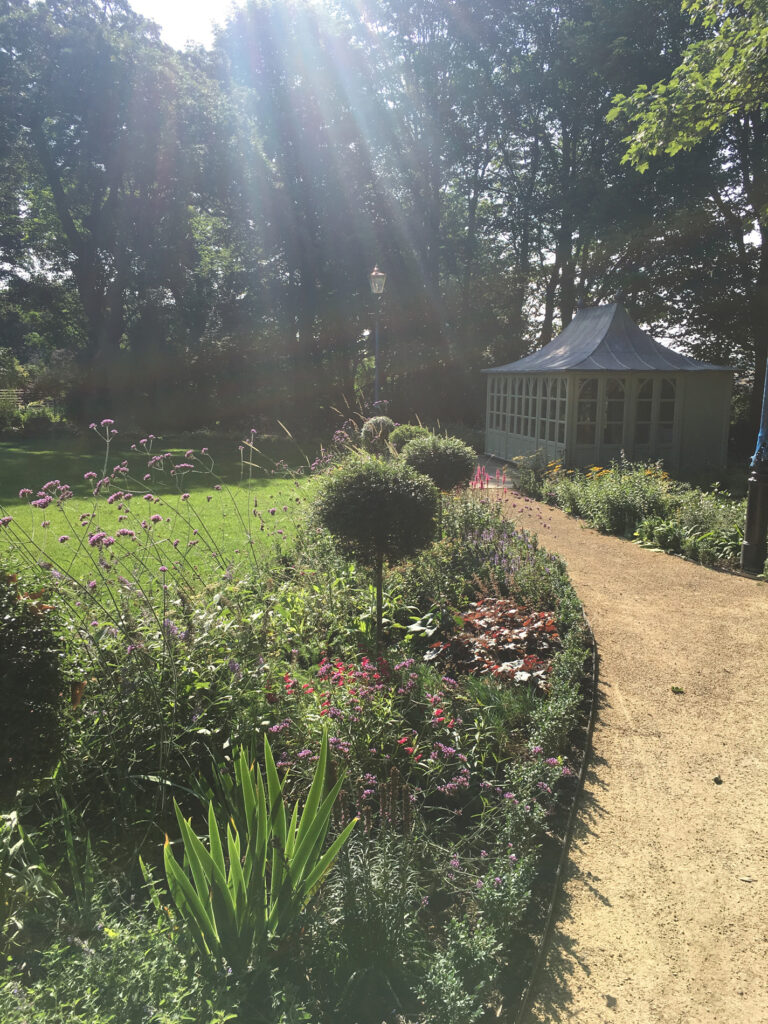 Planted beds and a path leading to a gazebo