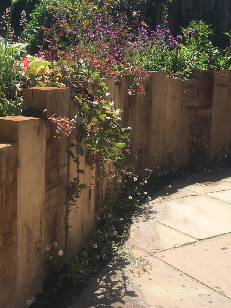 Raised flowerbed next to paved feature